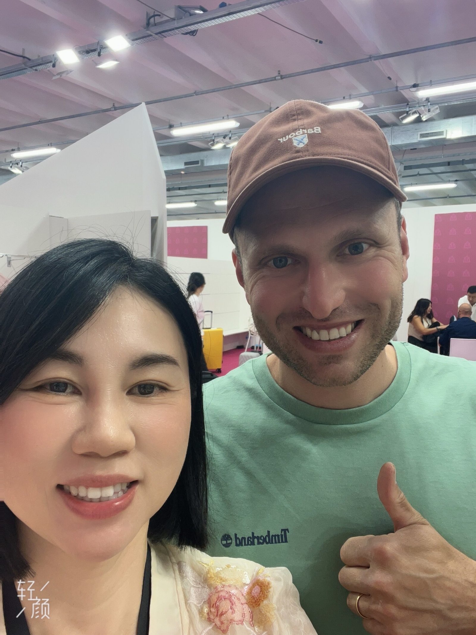 A person on a video call on a laptop, showing a factory in the background